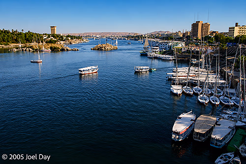 Ferries cross the Nile River, flowing past Aswan, Egypt