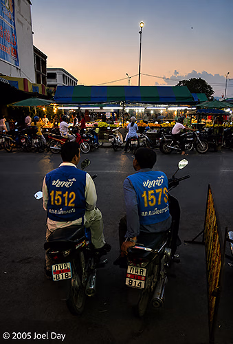 Motorcycle Taxi Drivers waiting to give rides at Night Markets in Krabi, Thailand